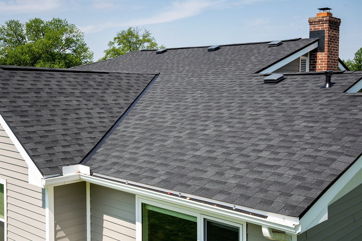 Huopakaton ja bitumikaton korjaus Jämsänkoski – luotettavaa palvelua kattosi parhaaksi. variables[width=1200,height=800,description=Photorealistic photo of a new shingle roof of detached house, picture taken from medium distance (showing some surroundings), not too deltailed, no text, no logos]