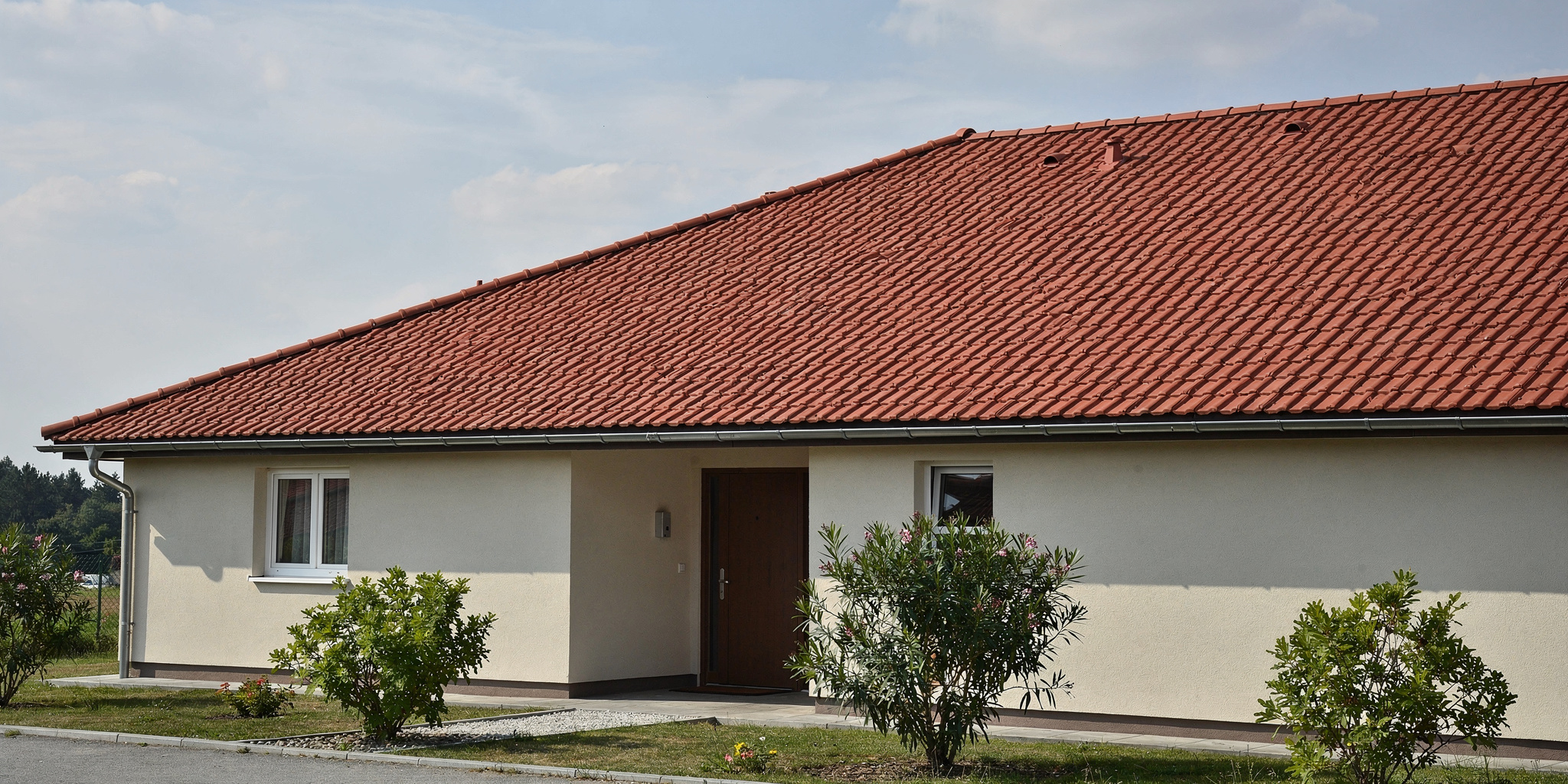 Katon korjaus variables[width=2048,height=1024,description=Photorealistic image from medium distance (showing some surroundings) of good condition tile roof OR metal sheet roof (choose one). Not too detailed. Natural daylight. No people, no text, no logos]