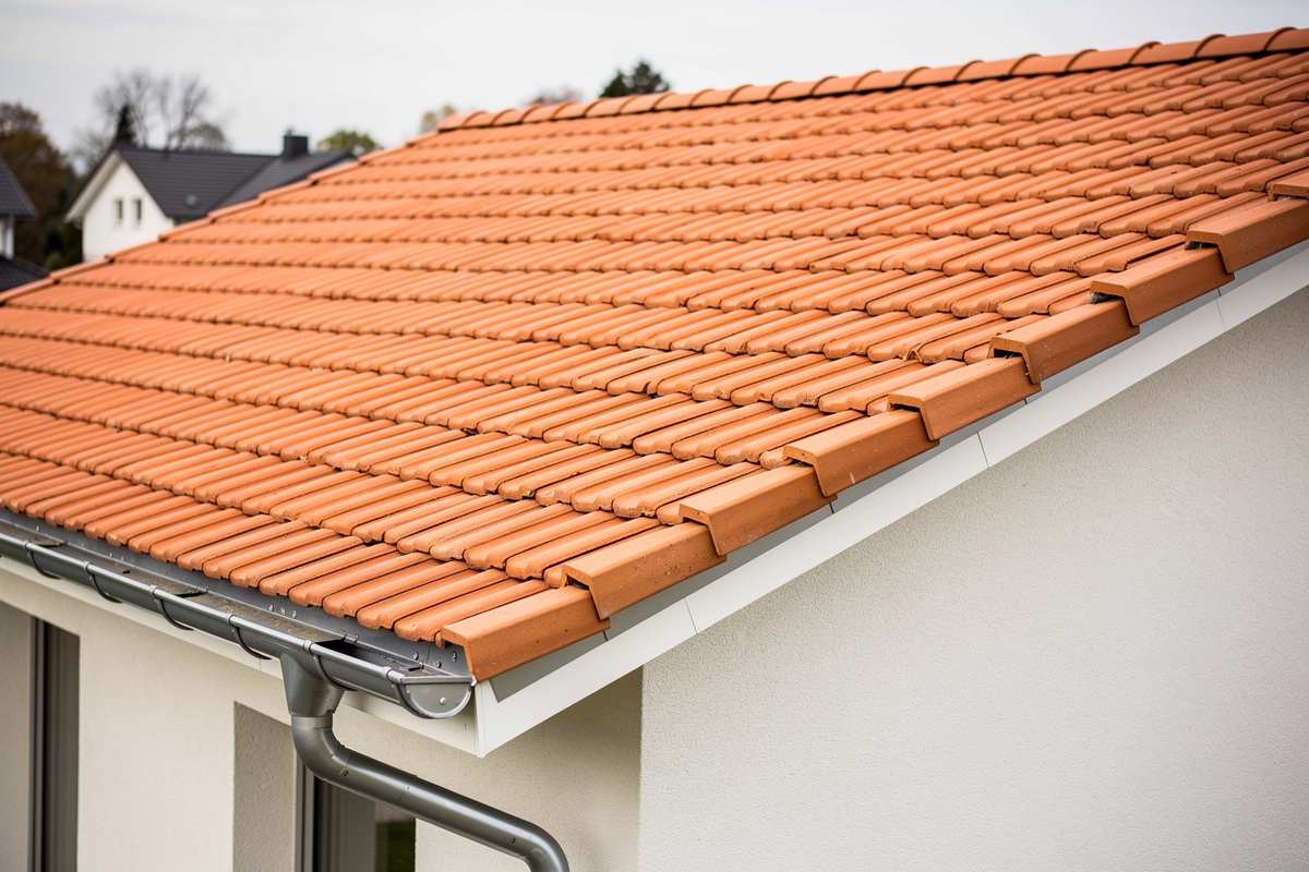 Tiilikaton korjaus Jämijärvellä palauttaa katon kauneuden ja toimivuuden variables[width=1200,height=800,description=Photorealistic photo of a new tile roof, picture taken from medium distance (showing some surroundings), not too deltailed, Nordic suburban house, No people, no text, no logos]